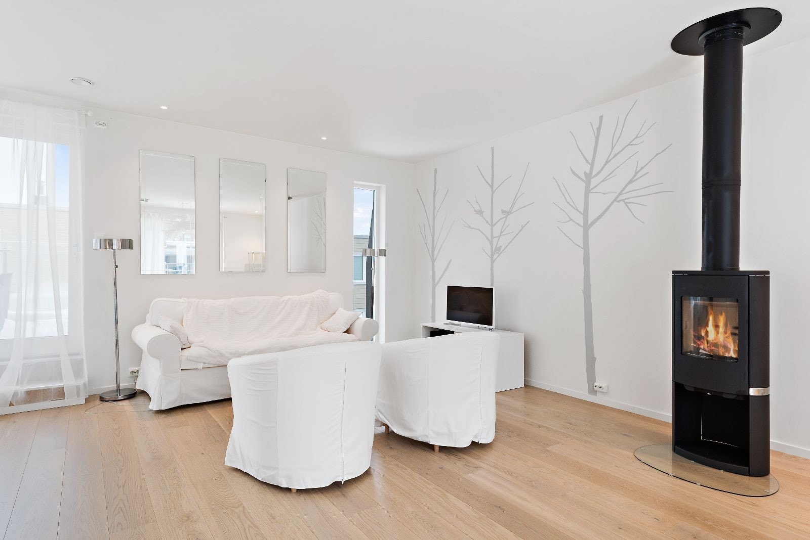 Utgang til balkong på ene siden av stuen og treplatting på den andre. Galleribilde