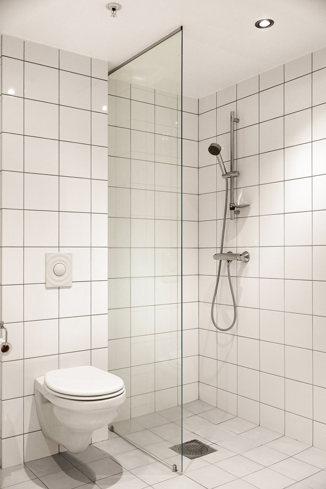 Flislagt bad med baderoms innredning, wc, dusjnisje og opplegg for vaskemaskin. Galleribilde