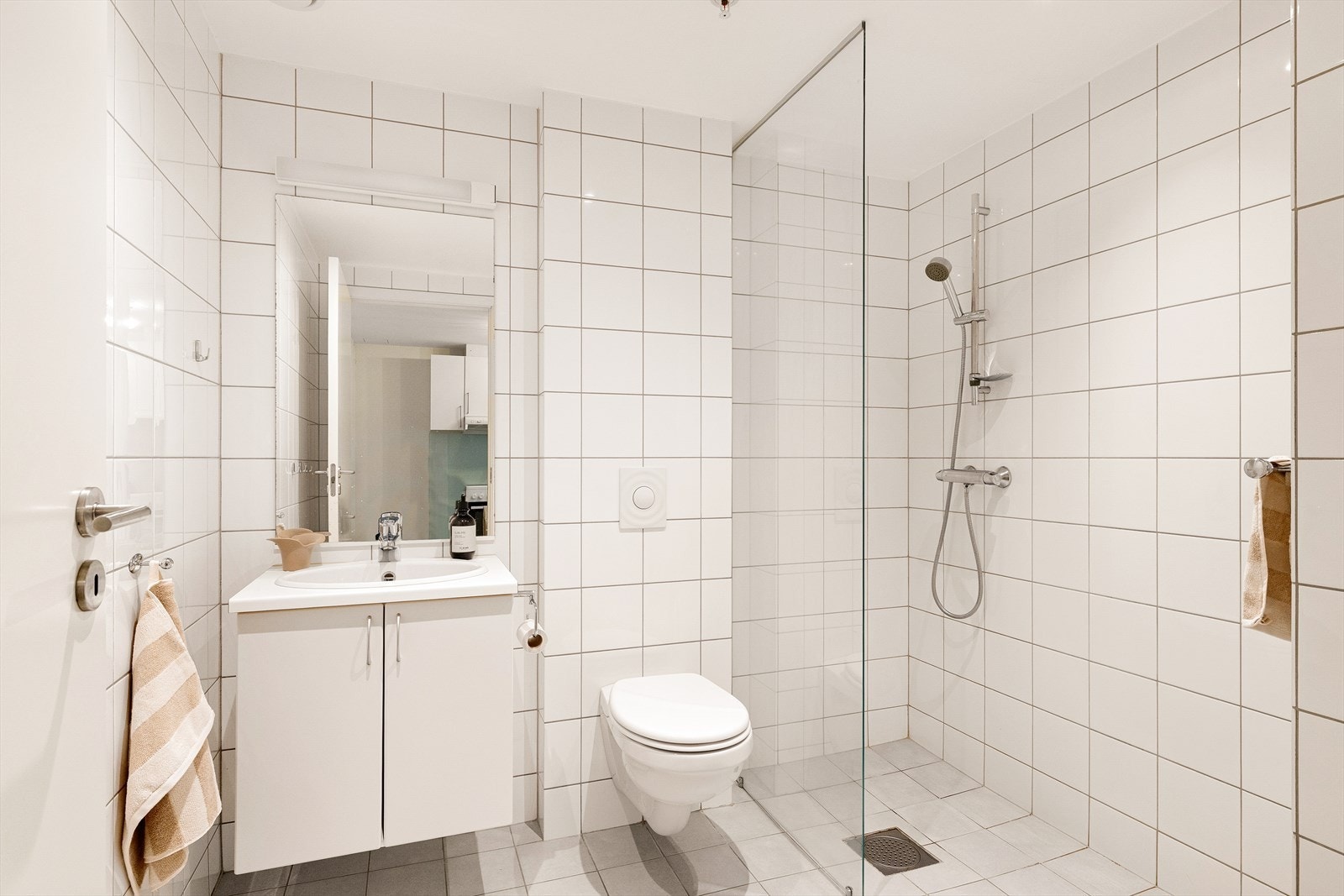 Flislagt bad med baderoms innredning, wc, dusjnisje og opplegg for vaskemaskin. Galleribilde