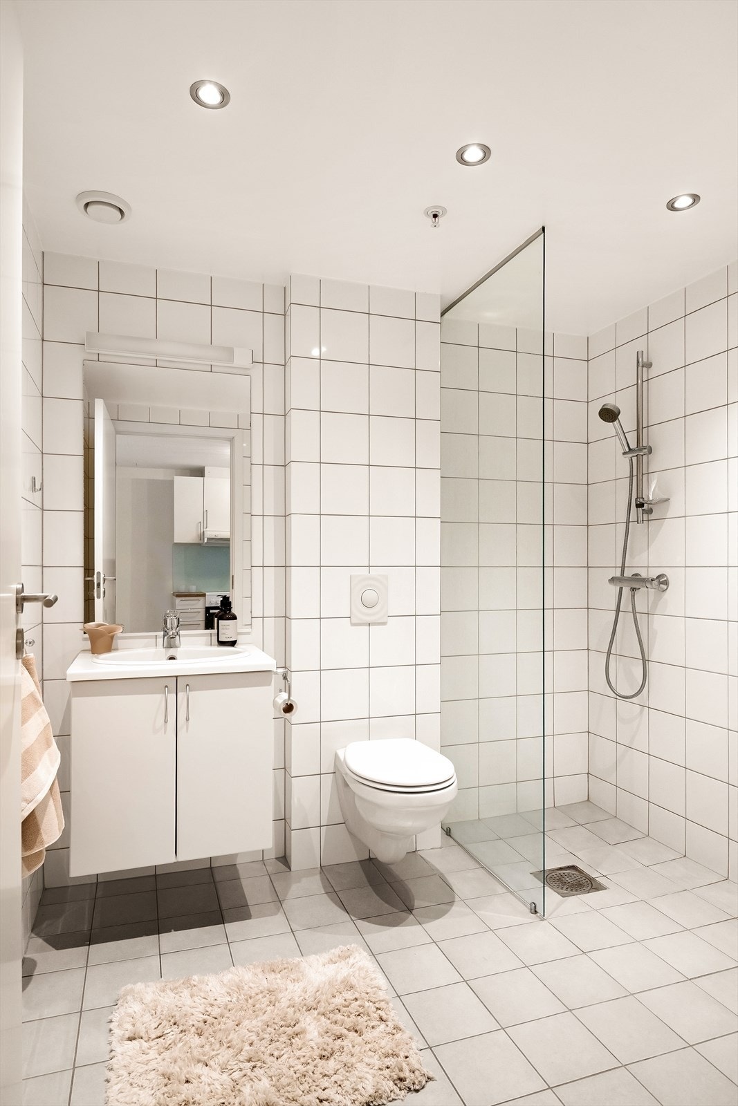 Flislagt bad med baderoms innredning, wc, dusjnisje og opplegg for vaskemaskin. Galleribilde