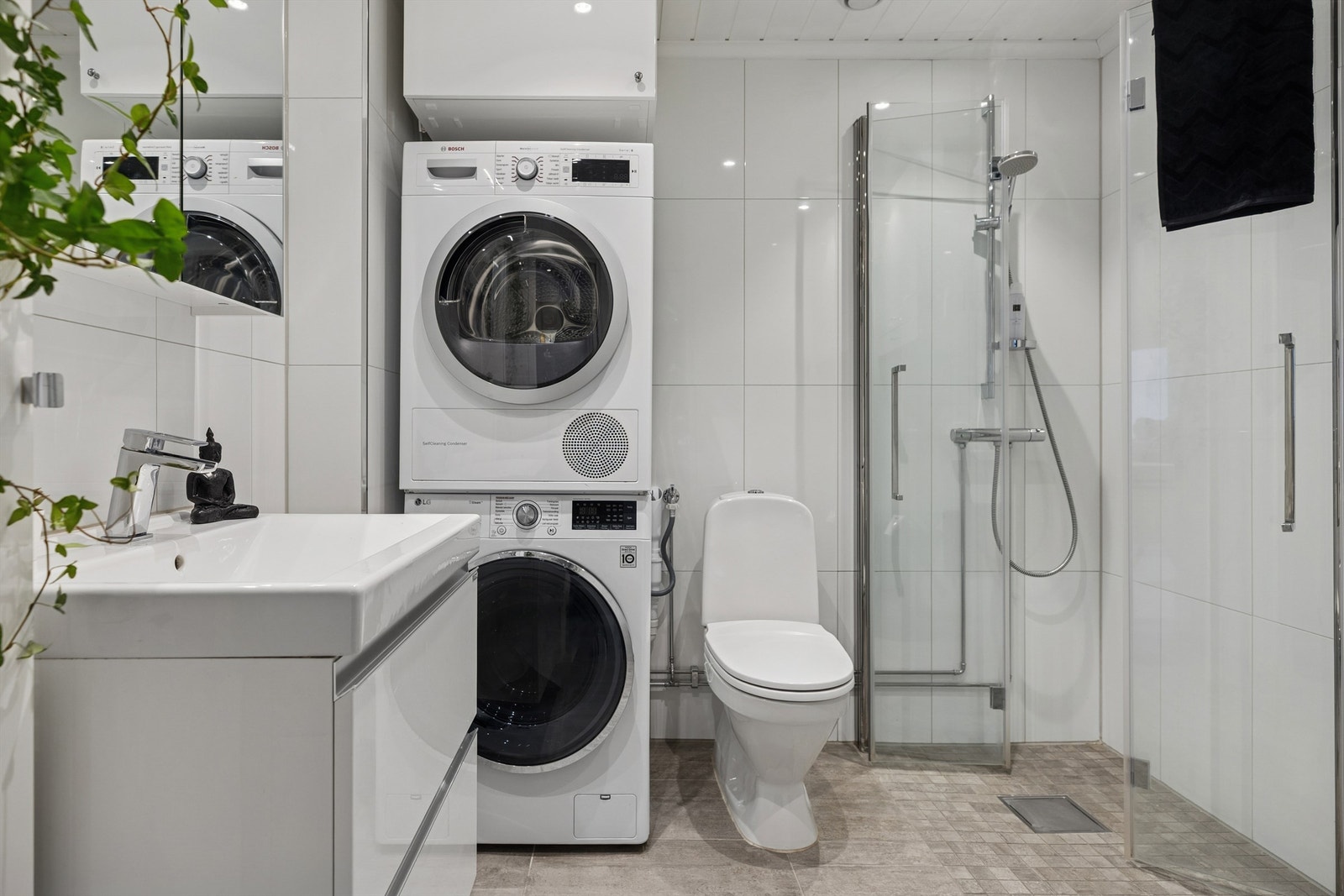 Stilrent og moderne flislagt bad fra 2017 med varme i gulv, servantskap, wc, dusjhjørne og plass til vaskesøyle. Galleribilde