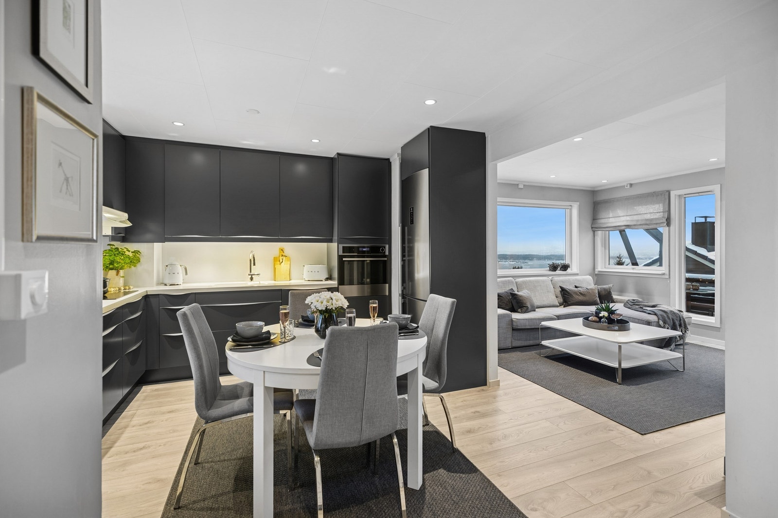 Den åpne løsningen mellom kjøkken og stue gir en luftig og harmonisk atmosfære, der gjennomlyset skaper en behagelig stemning året rundt. Galleribilde