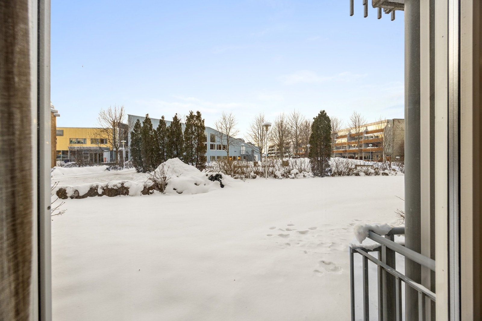 Utsikt over fellesareal med benker, busker og trær. Frodig og pent på sommeren! Galleribilde