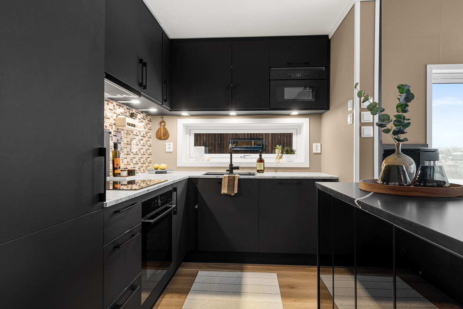 Kjøleskap med fryser, oppvaskmaskin, stekeovn, mikrobølgeovn og platetopp. Vegghengt ventilator. Komfyrvakt tilkoblet platetopp. Galleribilde