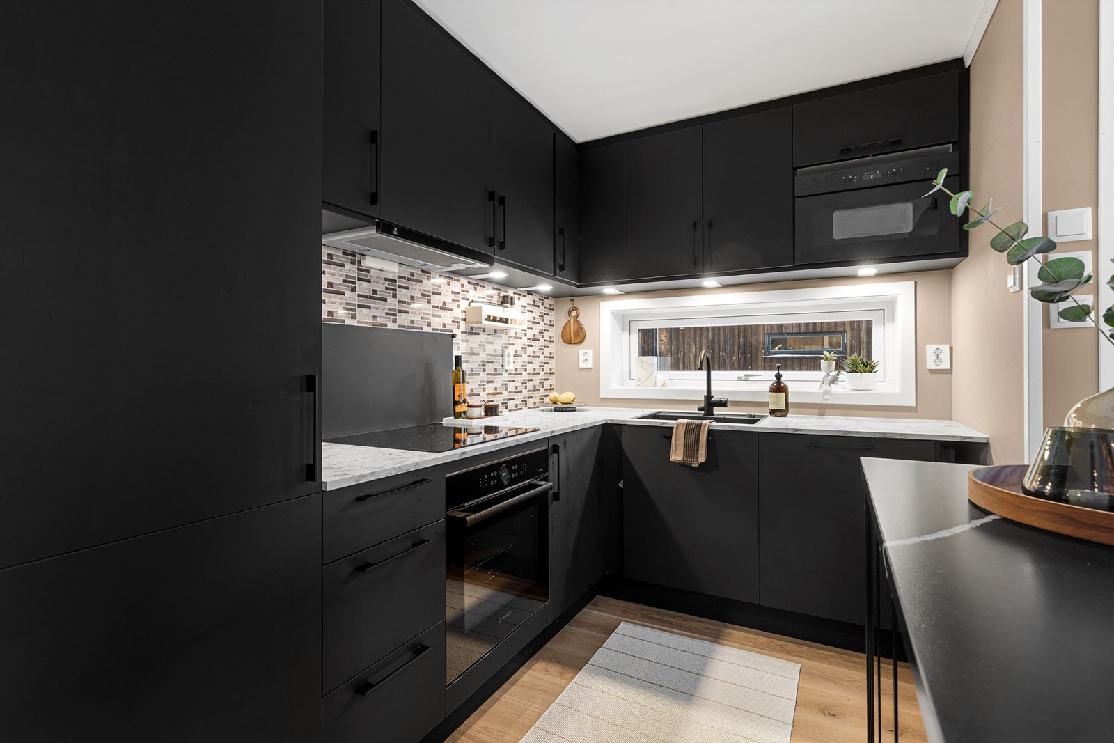 Kjøleskap med fryser, oppvaskmaskin, stekeovn, mikrobølgeovn og platetopp. Vegghengt ventilator. Komfyrvakt tilkoblet platetopp. Galleribilde