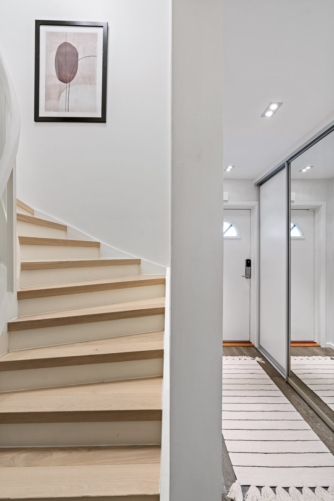 Entreen er i 1. etasje og har downlights, store gulvfliser og hvitmalte vegger. Langs den ene veggen er det mye oppbevaring i en plassbygd skyvedørsgarderobe med dels speilfronter. Galleribilde