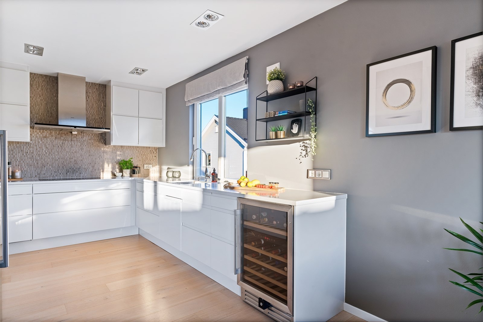 Over endeveggen er mosaikkfliser montert, og over kokesonen har kjøkkenet en komfyrvakt og en ventilator med avtrekk ut. Galleribilde