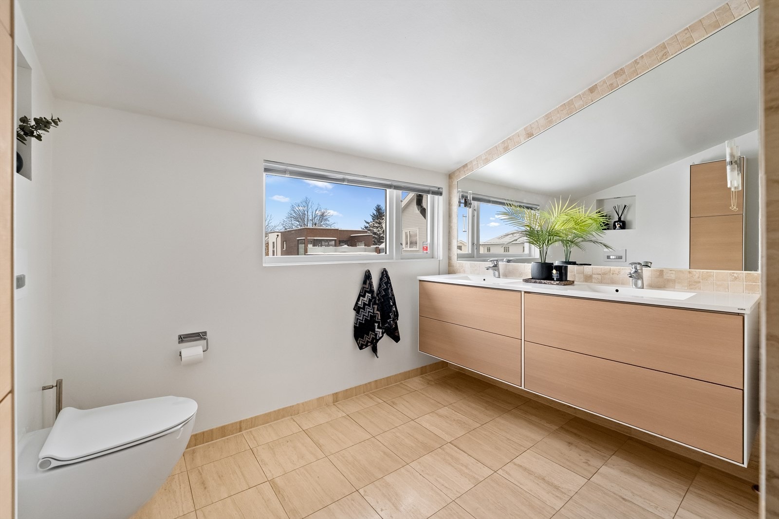 Badet ble smakfullt pusset opp i 2013, og beige gulvfliser kombineres med matchende fliser og hvitmalte flater på veggene. Galleribilde