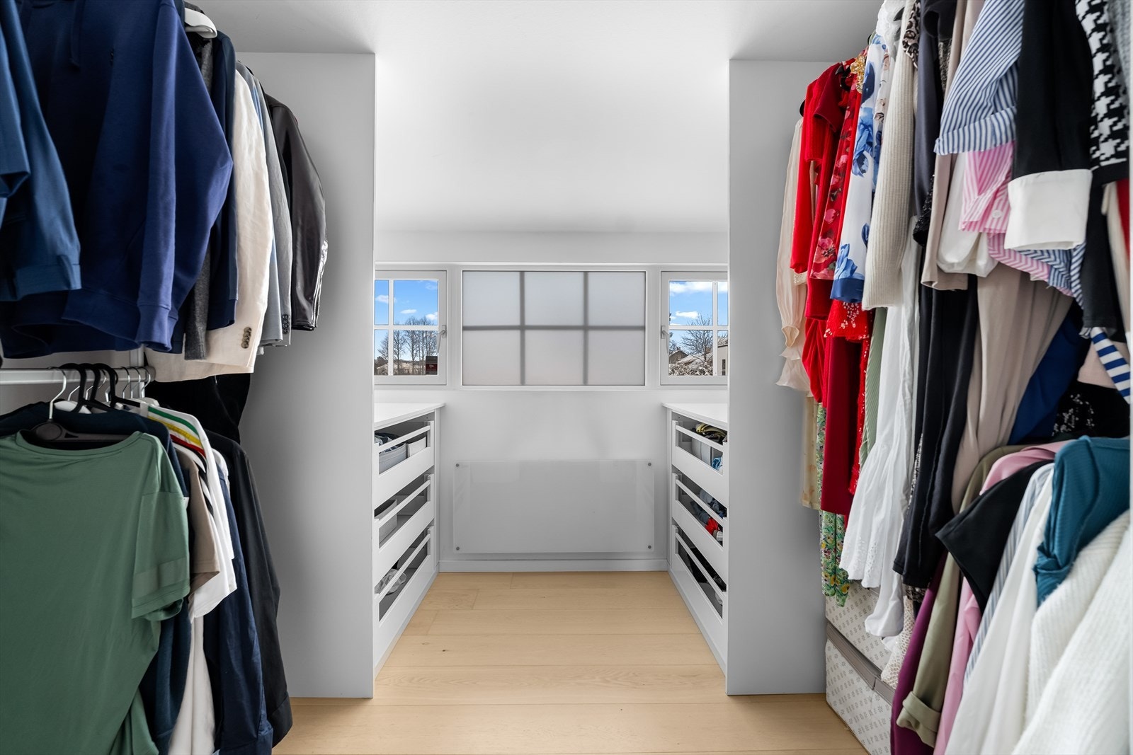 I gangen utenfor har boligen et eget walk-in closet med kommoder og klesoppheng i ulike høyder. Galleribilde