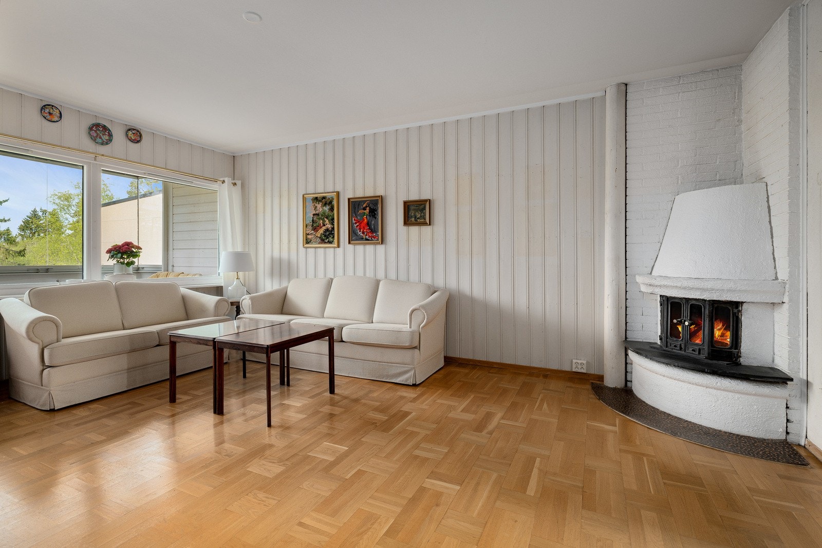 Den romslige stuen har en sentral plassering i leiligheten og en stemningsfull peis. Galleribilde