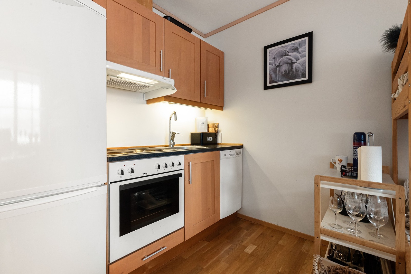 Kjøkkenet har kjøkkeninnredning i folierte plater med over- og underskap. Integrerte hvitevarer med komfyr, koketopp og ventilator Galleribilde