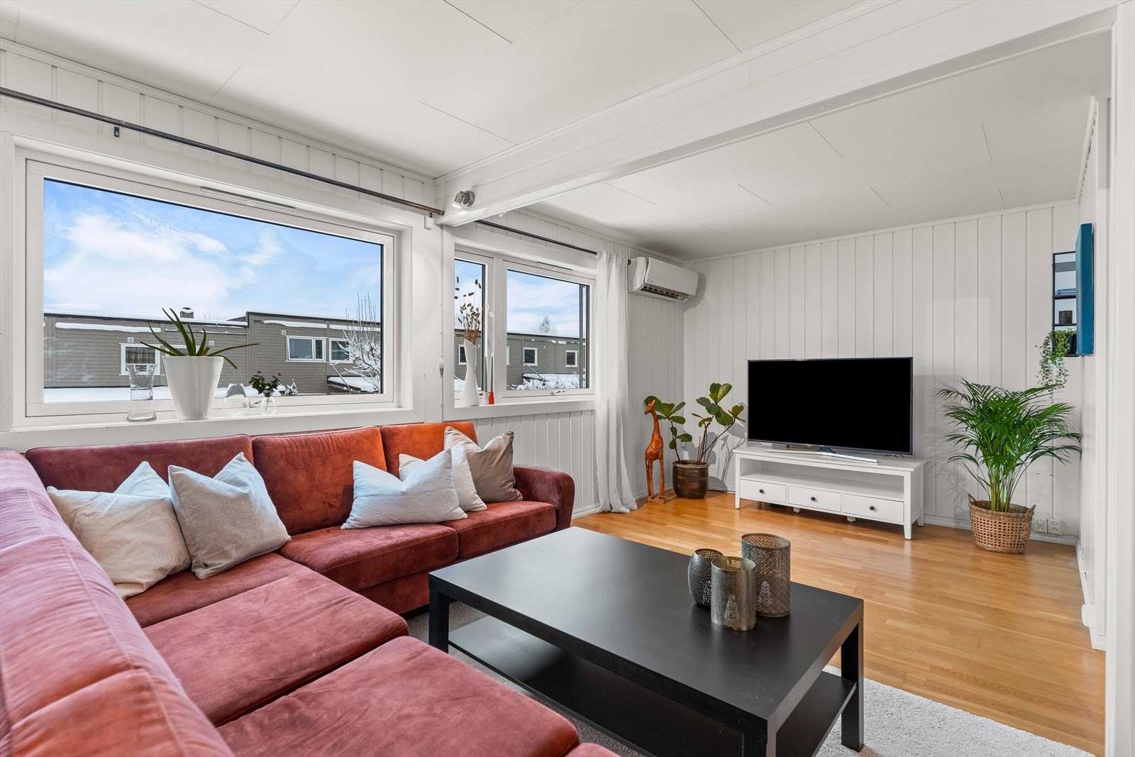 Oppholdsrom med god plass til sosial sone og TV-løsning. Tidløse overflater og gjennomgående parkett. Galleribilde