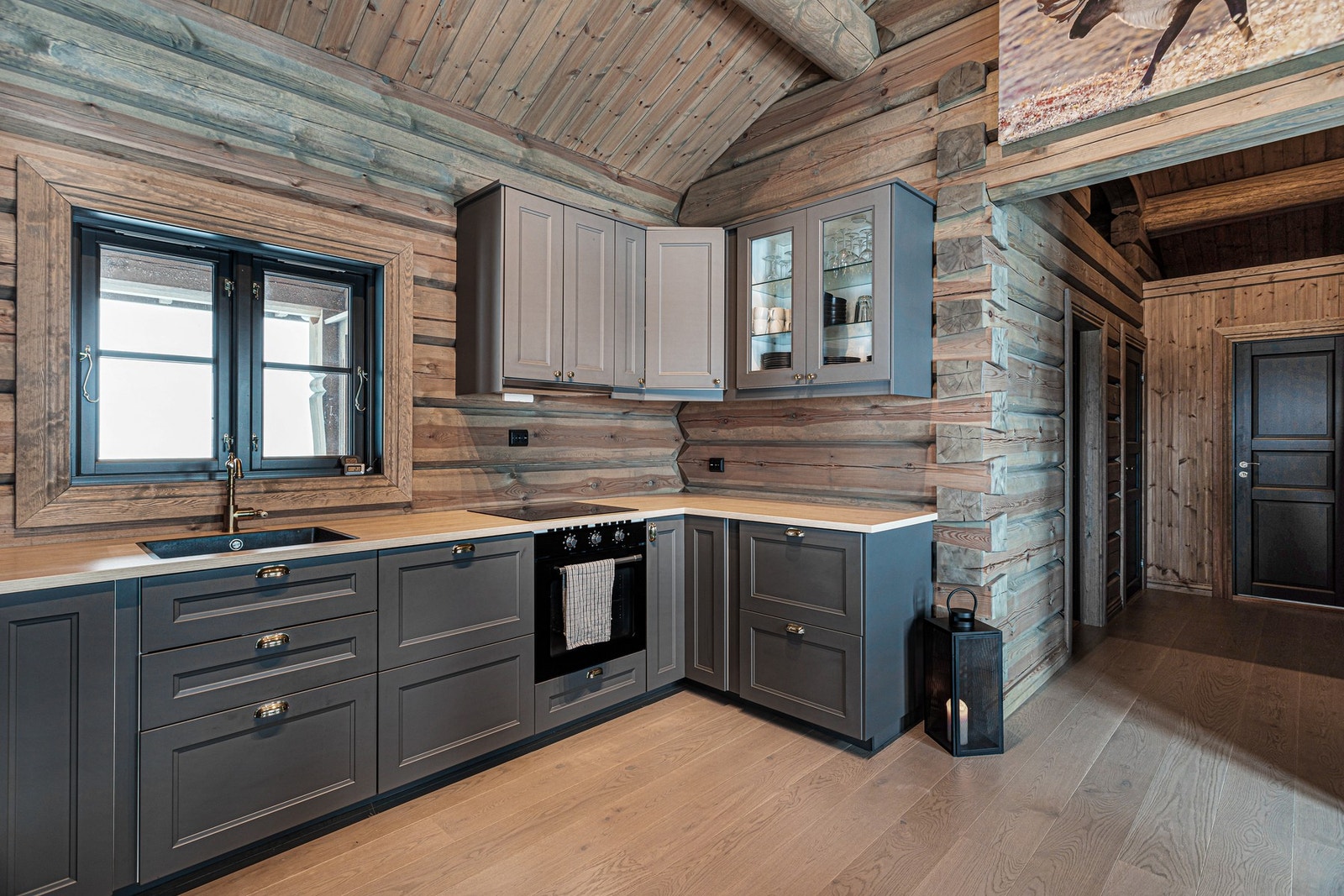 Kjøkkenet har integrerte hvitevarer som komfyr, induksjonstopp, oppvaskmaskin og kjøl/frys Galleribilde