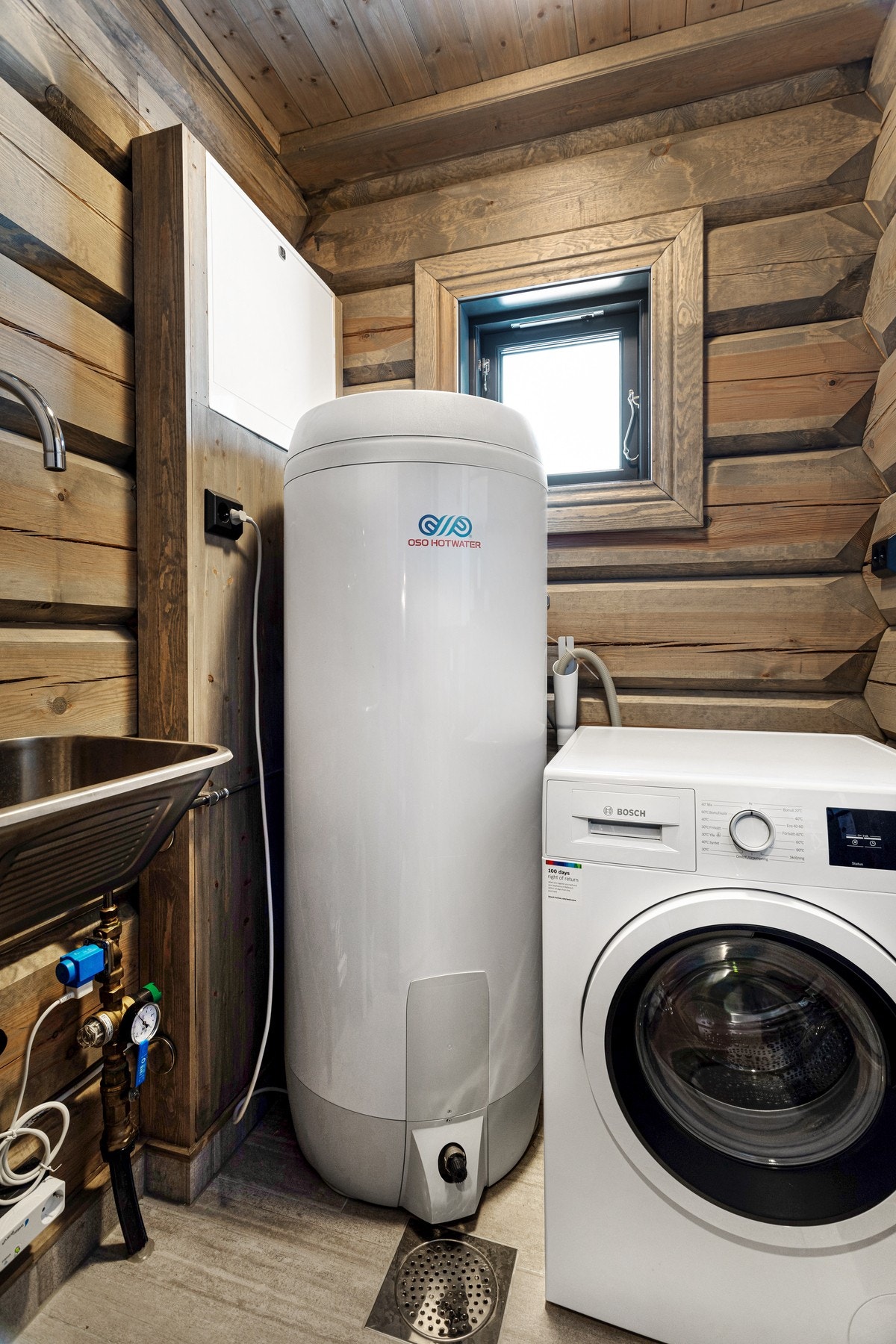 Vaskerom har flislagt gulv og er innredet med bla. opplegg til vaskemaskin, varmtvannstank på 230 liter og utslagsvask Galleribilde