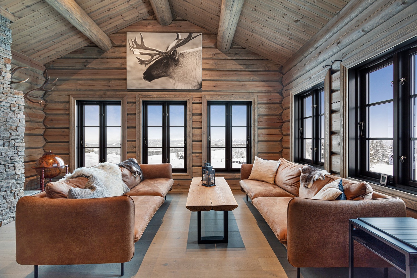 Laftet tømmer på vegg, parkett på gulv og skiferbelagt pipe bidrar til den ultimate hyttestemningen Galleribilde