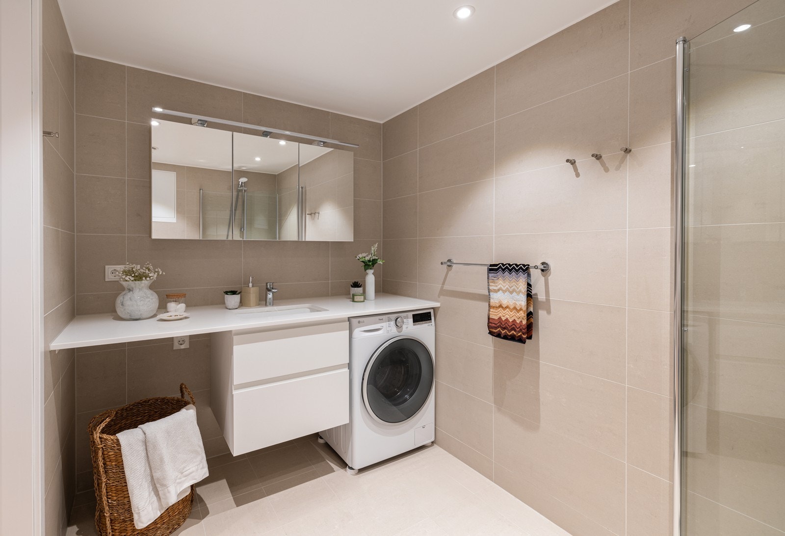 Delikat hovedbad med dusjhjørne og moderne innredning. God oppbevaringsplass og tidløse fliser. Opplegg for vaskemaskin. Galleribilde