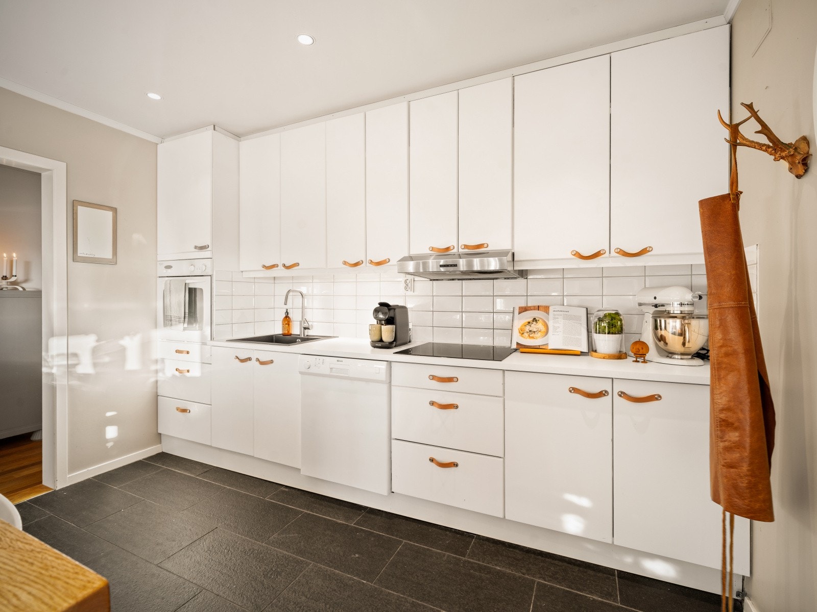 Lyst kjøkken innredning med glatte fronter, laminat benkeplate og nedfelt vaskekum. Galleribilde