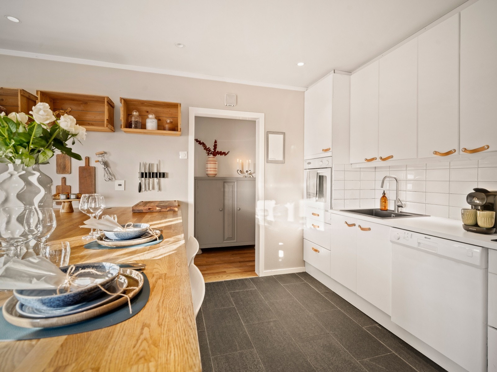 Kjøkkeninnredningen har lyse glatte fronter og en benkeplate av laminat med nedfelt vask, og en praktisk kjøkkenøy med heltre benkeplate. Galleribilde