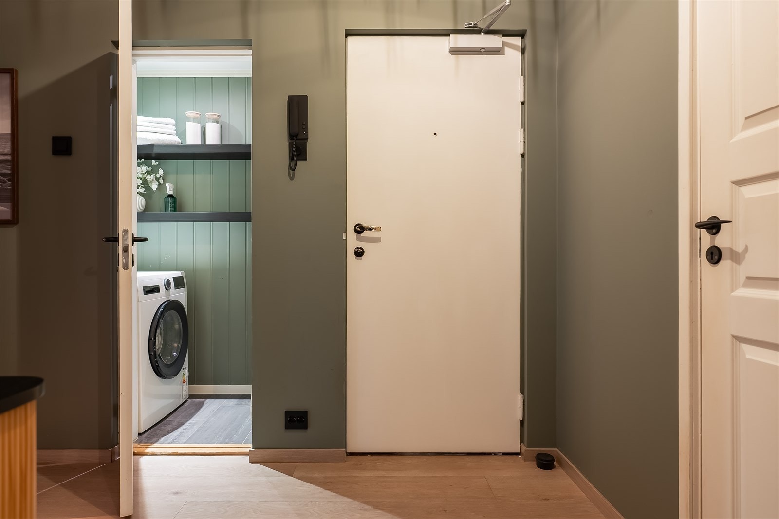 Romslig entré med god plass til oppbevaring. Fra entré finner man leilighetens innvendige bod, som benyttes som vaskerom - en praktisk og plassbesparende løsning. Galleribilde