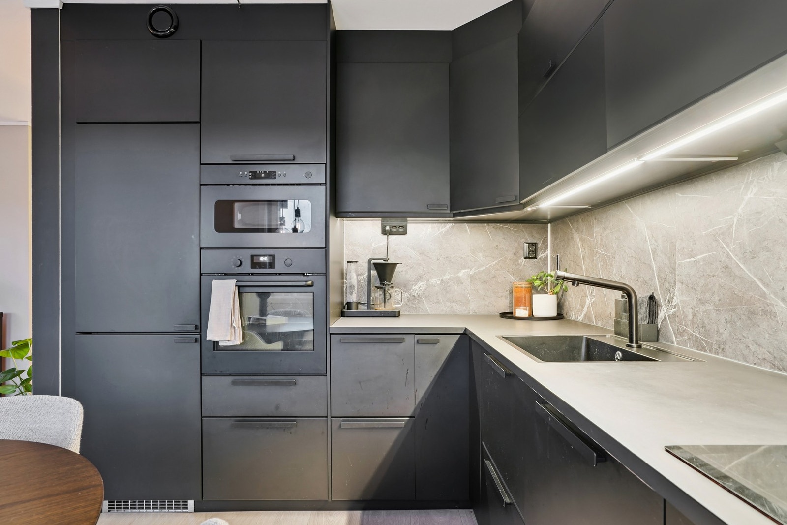 Innredning med sorte glatte fronter og laminat benkeplate fra Ikea (2020). Belysning under overskap. Galleribilde