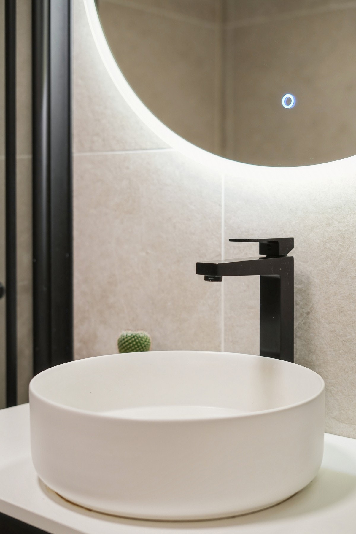 Moderne servant med sort armatur og belyst speil - et gjennomført og tidløst uttrykk. Galleribilde