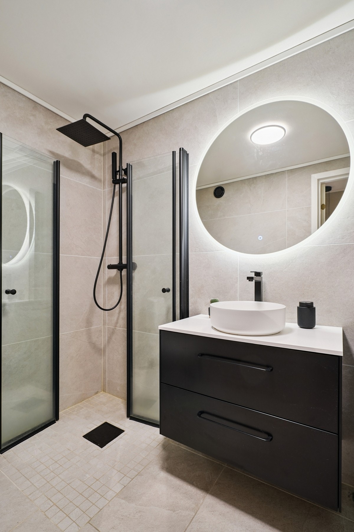 - servantinnredning med overliggende servant og rundt speil med integrert belysning. Galleribilde