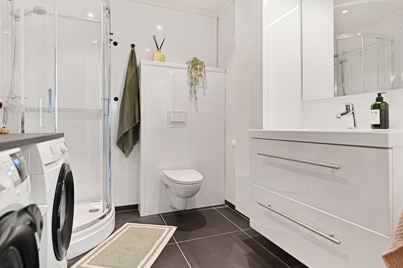 Begge leilighetene har baderom med dusjkabinett og opplegg for vaskemaskin. Galleribilde