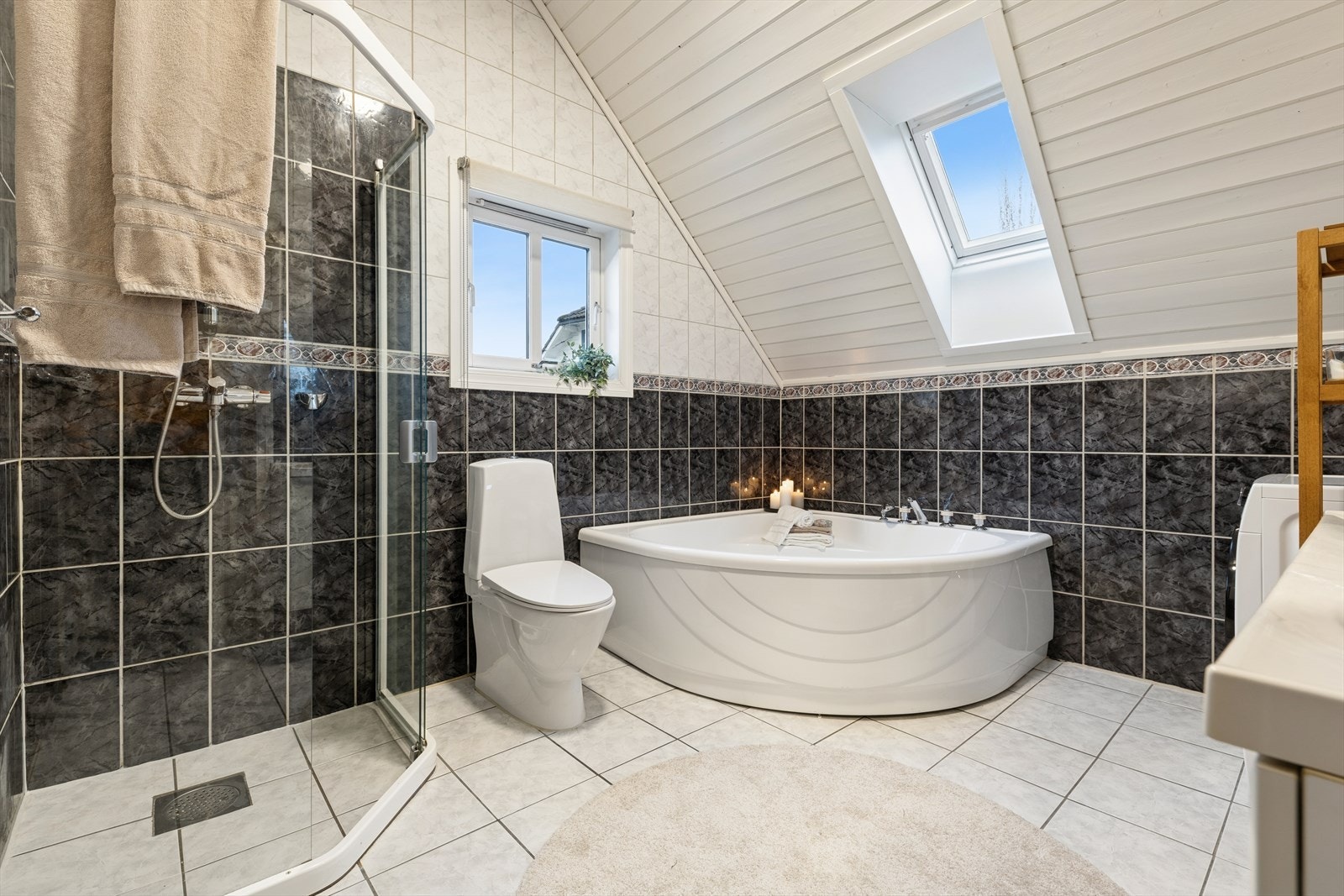 Badet er utstyrt med badekar, dusjsone, toalett, lys baderomsinnredning med speil og opplegg for vaskemaskin. Galleribilde