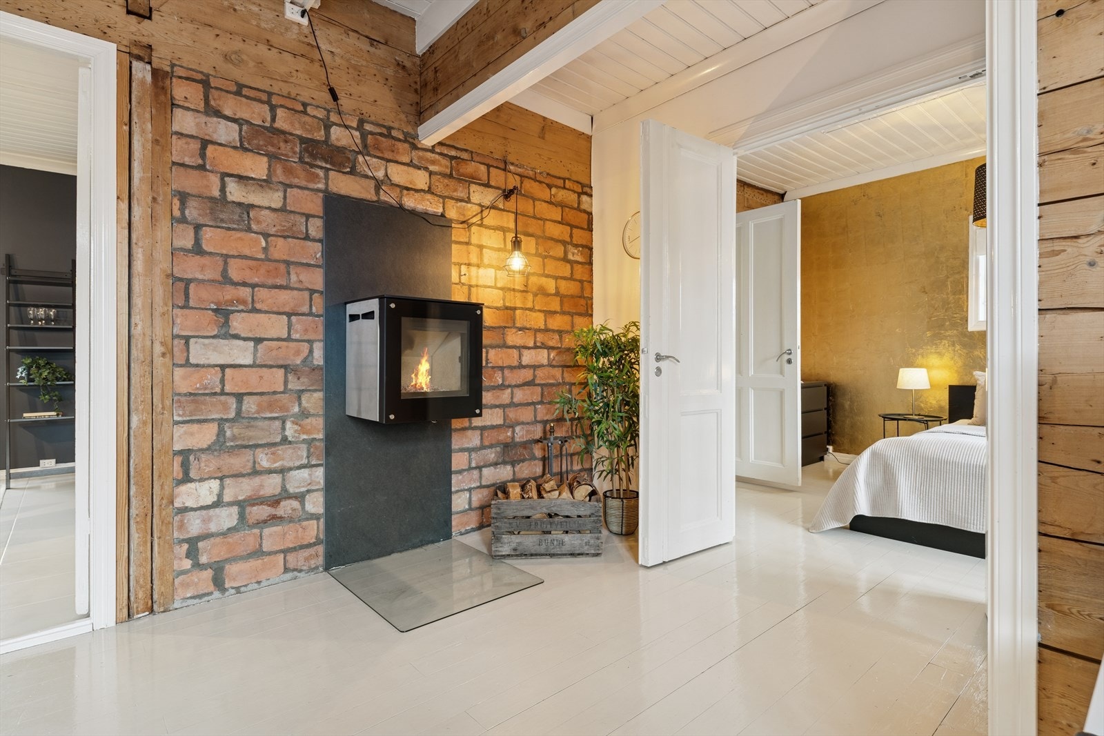 Stuen lenger inn har god takhøyde, originale laftevegger og detaljer i teglstein som harmonerer godt sammen og gir et tydelig historisk preg. Galleribilde