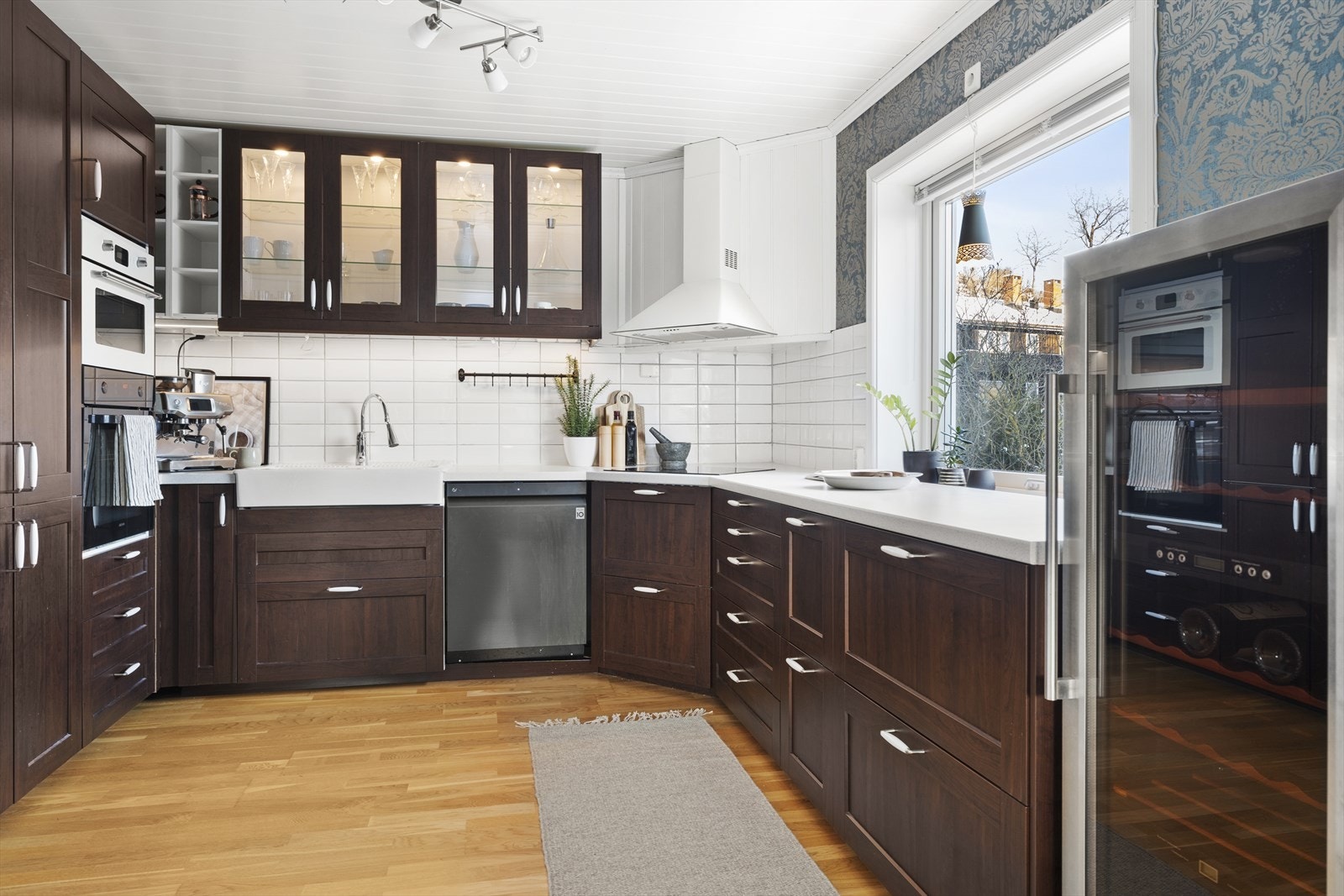 Kjøkkeninnredningen er godt tilpasset rommets utforming og har godt med skap- og benkeplass Galleribilde