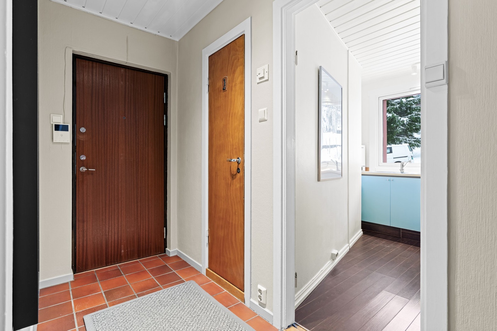 Inngangspartiet har flislagt gulv og malt tapet på veggene, noe som gir et enkelt og funksjonelt uttrykk Galleribilde