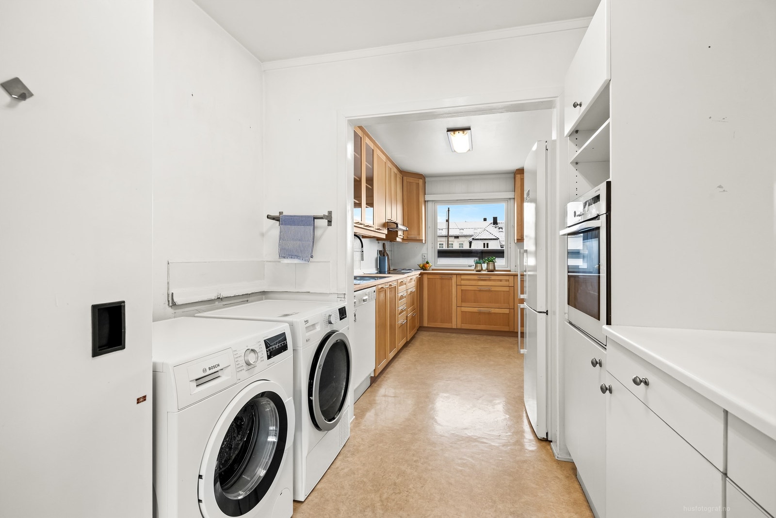 Rommet har skapinnredning med over- og underskap i hvit samt glatt utførelse Galleribilde