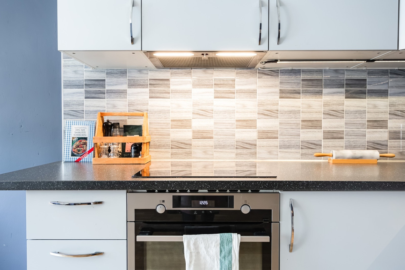 Det er praktisk belysning over benken, samt flisfelt mellom overskap og kjøkkenbenk som gir et stilfullt preg. Galleribilde