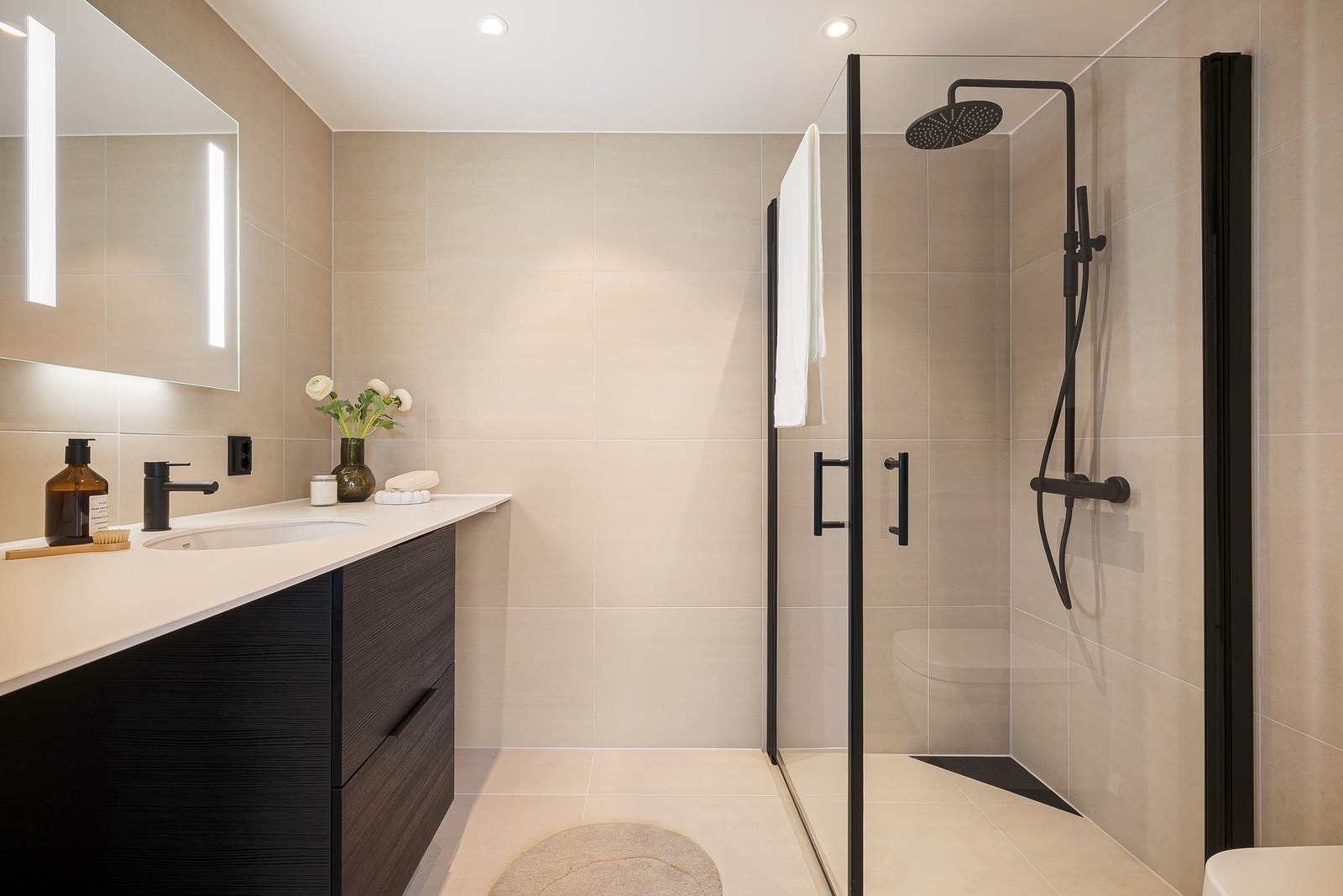 Lekkert og påkostet bad på ca. 5 kvm med plass til både vaskemaskin og tørketrommel under benkeplaten. Galleribilde