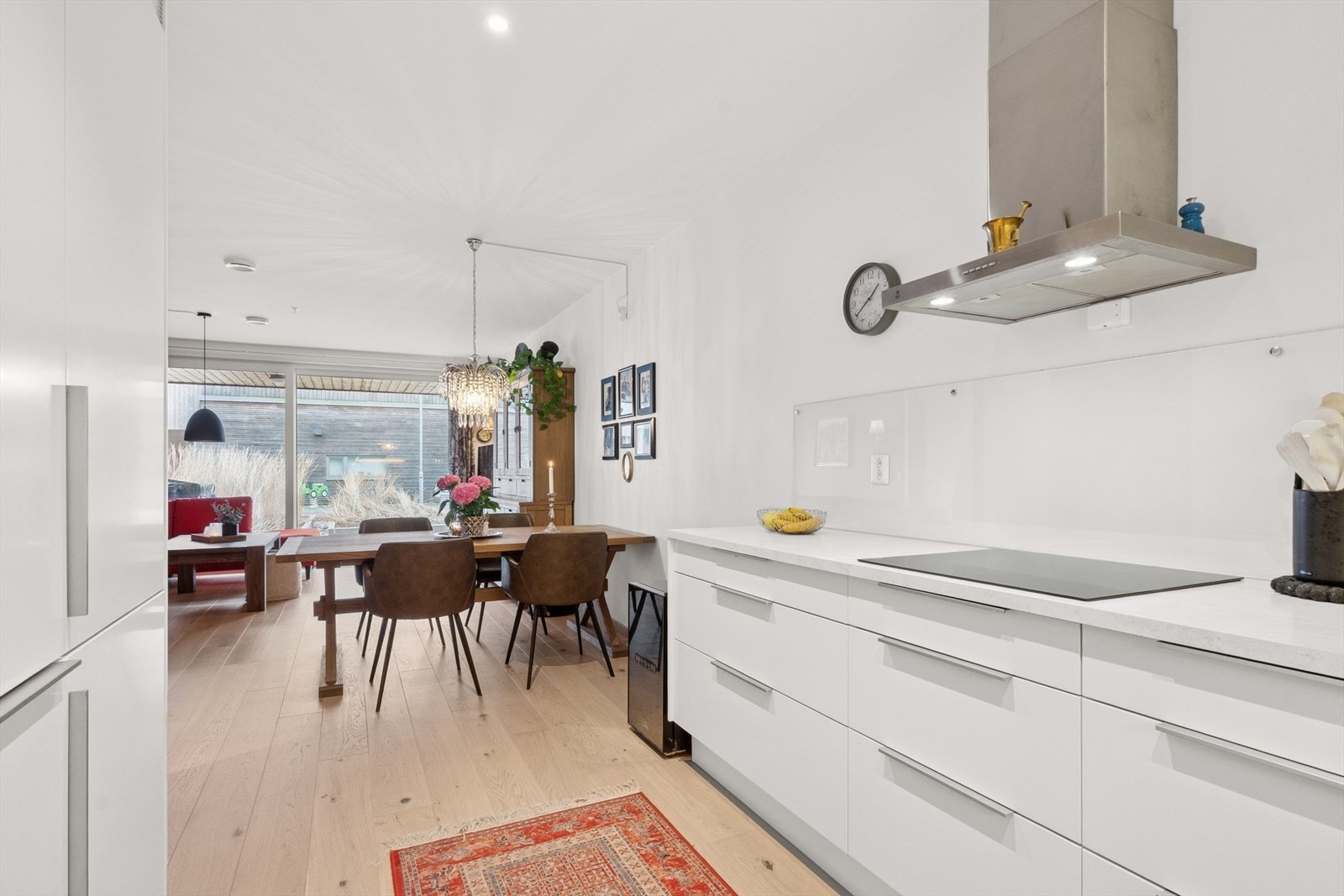 Over benken er det fritthengende ventilator med komfyrvakt, benkebelysning og glassplater på veggene i bakkant. Hvitevarene fra Siemens er integrert og består av koketopp, stekeovn, oppvaskmaskin og kjøl/frys. Galleribilde