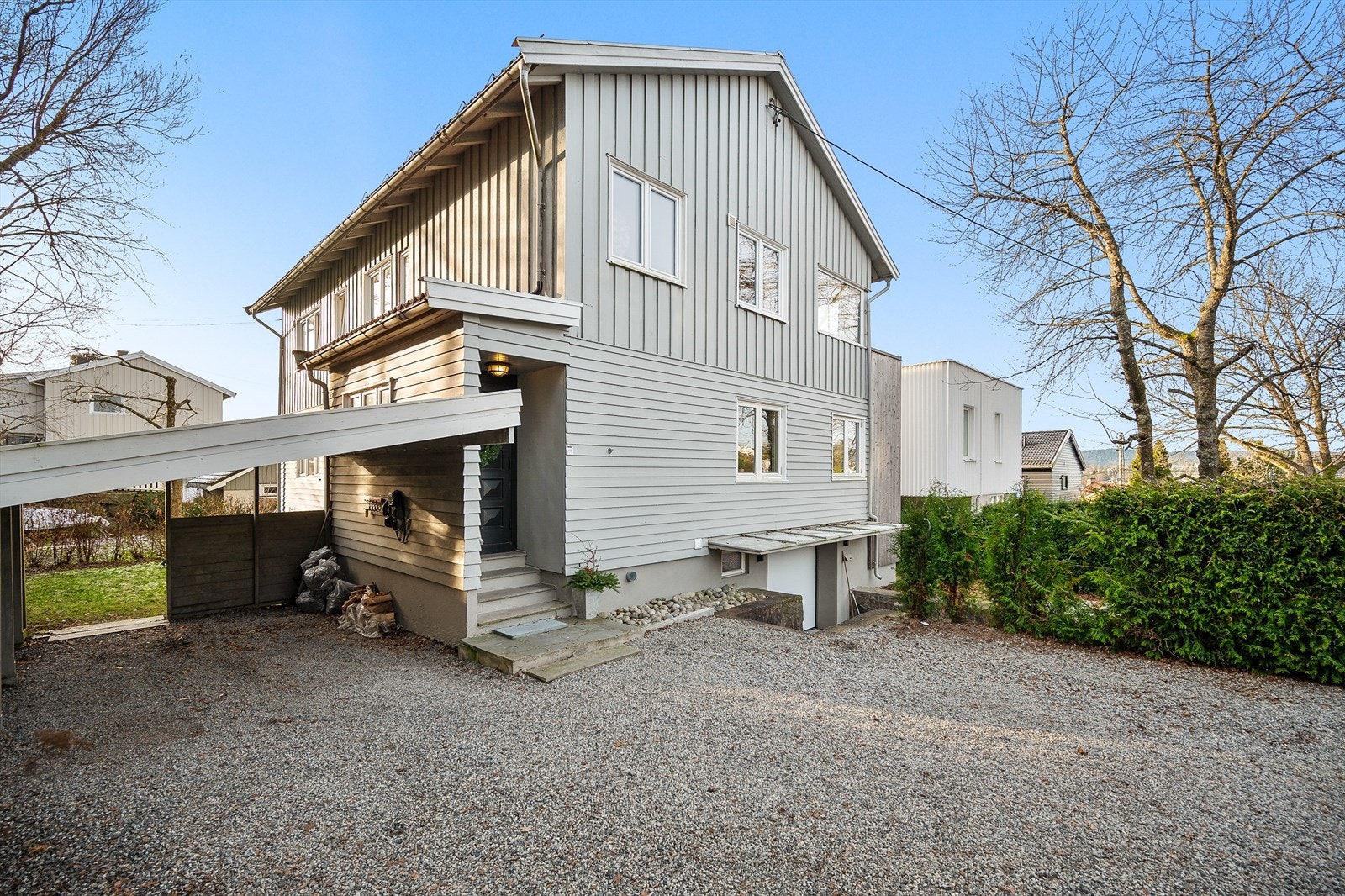 Boligen har gruset gårdsplass med parkering og et hyggelig inngangsparti Galleribilde