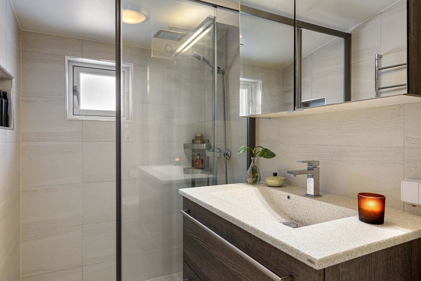 Badet er innredet med vegghengt klosett, baderomsinnredning med heldekkende servant, speilskap og dusjvegg. Elektrisk styrt vifte. Galleribilde