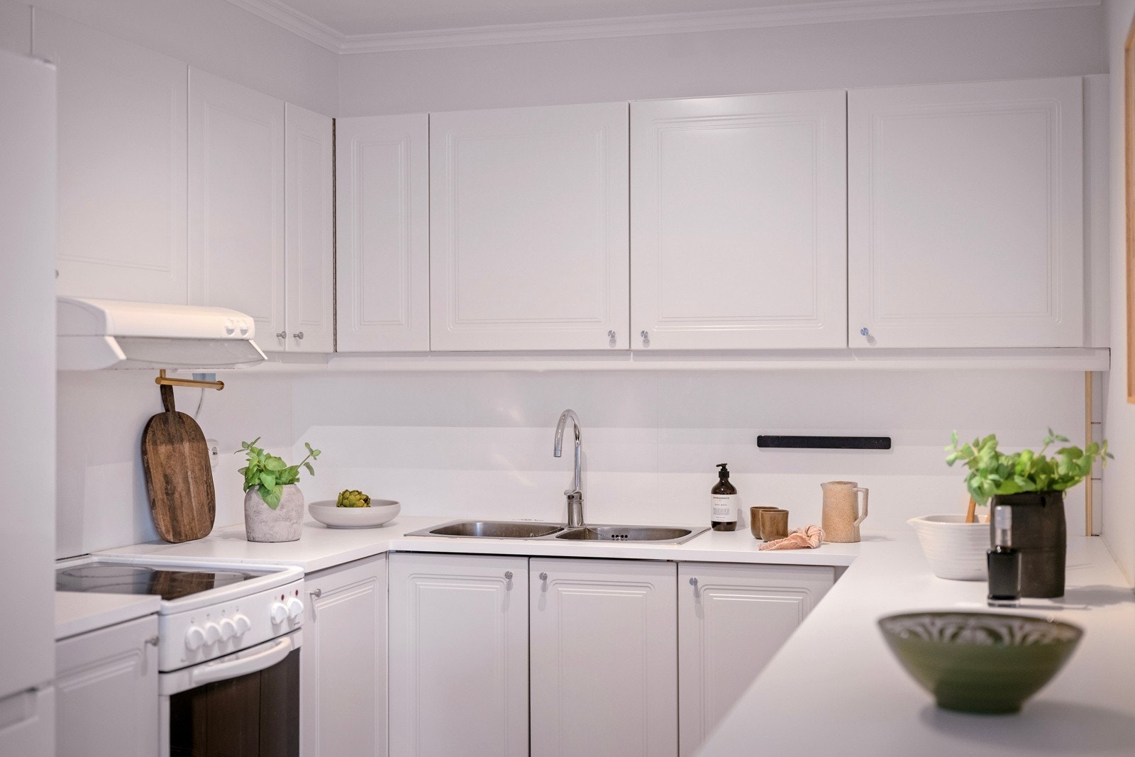 Her får du god skapplass, integrerte hvitevarer og lyse benkeplater. Galleribilde