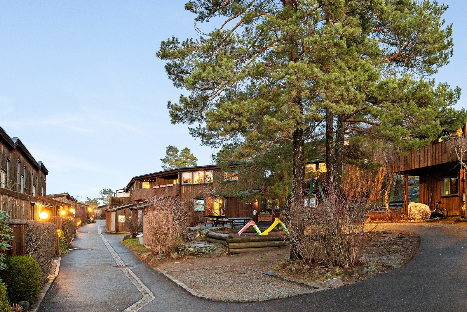 Tomten er opparbeidet med asfalterte internveier, steinsatte arealer, blomsterbed, variert beplantning, lekeapparater og sittegrupper samt noe naturtomt. Galleribilde