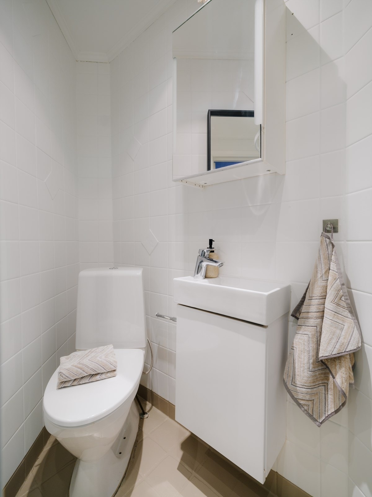 Innredning bestående av dusjkabinett, servant, klosett, benkeskap, veggskap og speil over servant Galleribilde