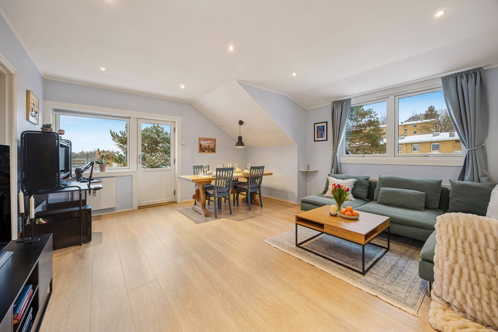 Lys laminat på gulv og vinduer fra flere vinkler gir rommet en åpen og luftig følelse. Galleribilde