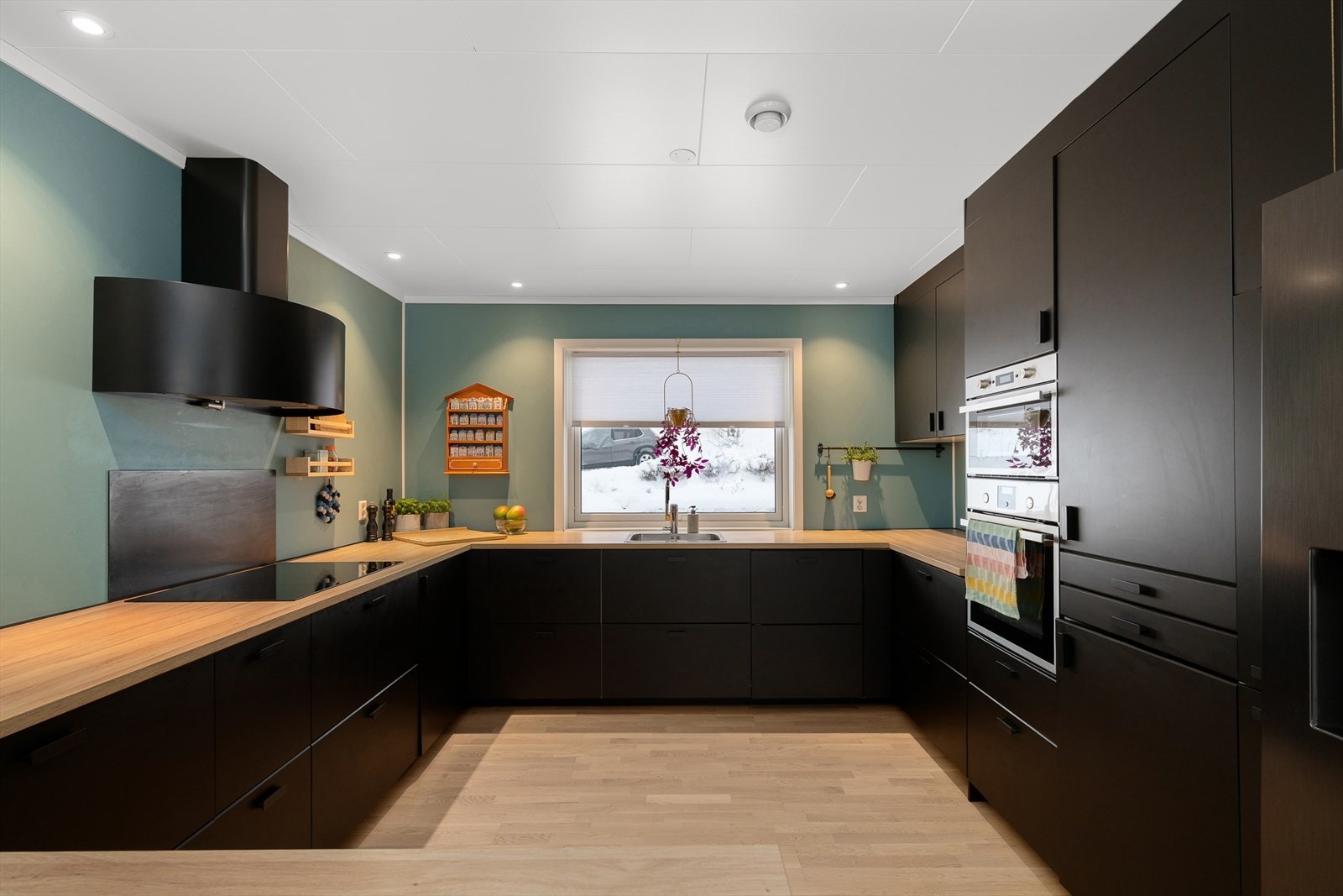 Moderne kjøkkeninnredning med slette, svarte fronter og rikelig med skap- og benkeplass. Galleribilde