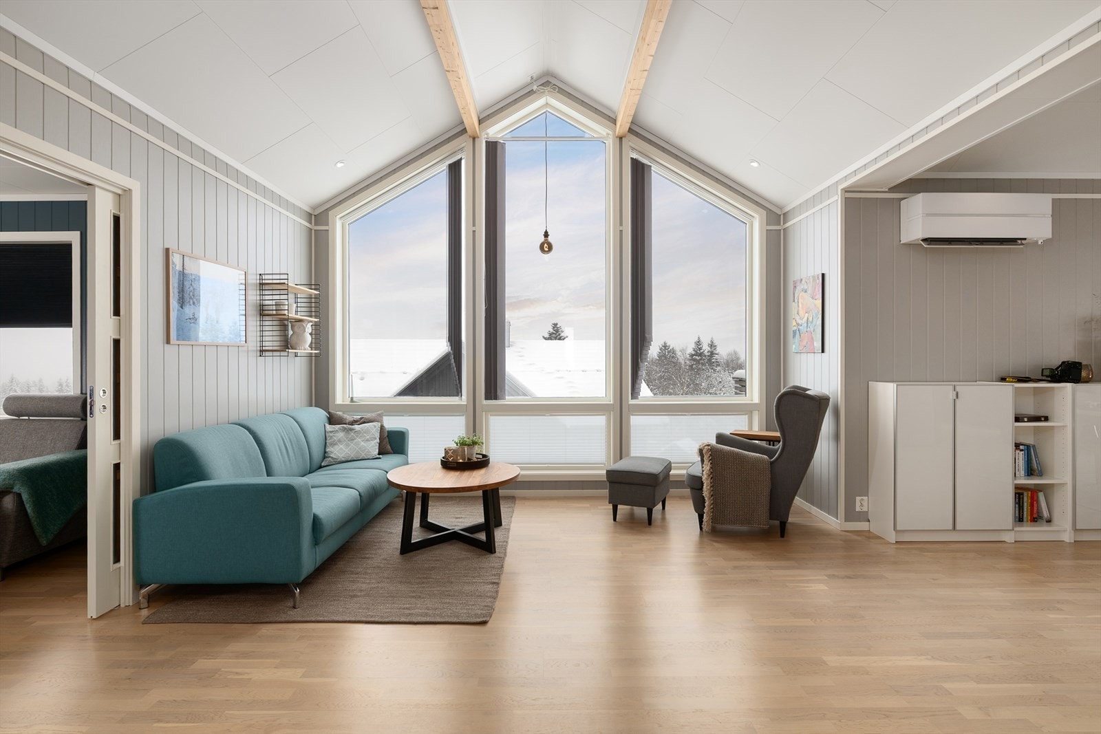 Stuen har store vindusflater fra gulv til tak som gir rikelig med naturlig lys. Galleribilde