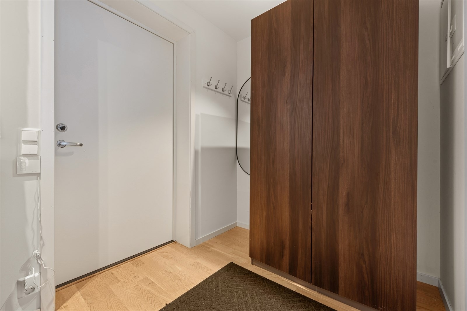 Velkommen inn i en innbydende entré som gir et ryddig og godt førsteinntrykk. Her er det eikeparkett på gulv og lyse, slette veggflater som skaper et moderne og tidløst uttrykk. Galleribilde