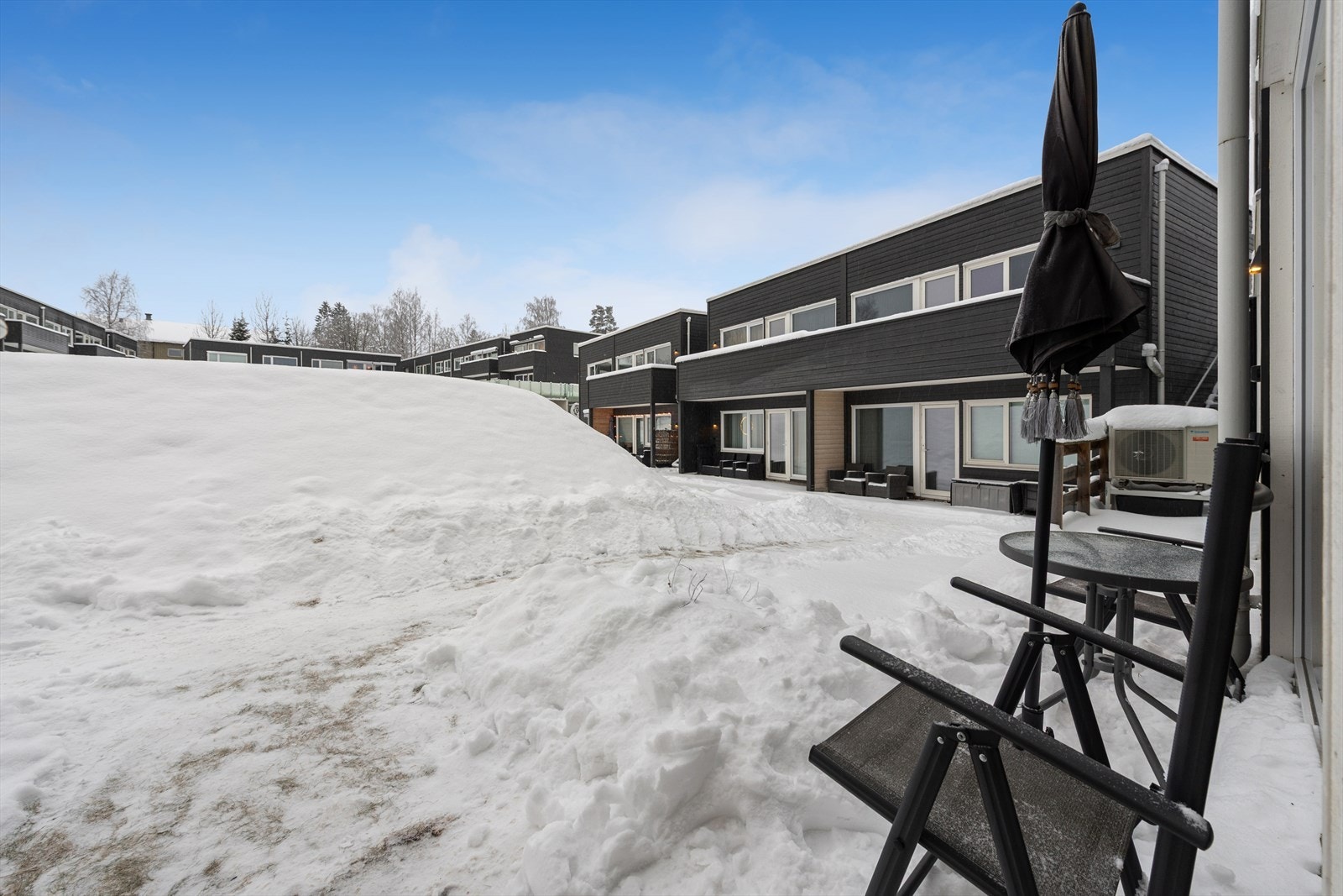 Utgang fra stue til markterrasse med betongheller gir hyggelig uteplass som vender mot fellesareal. Galleribilde