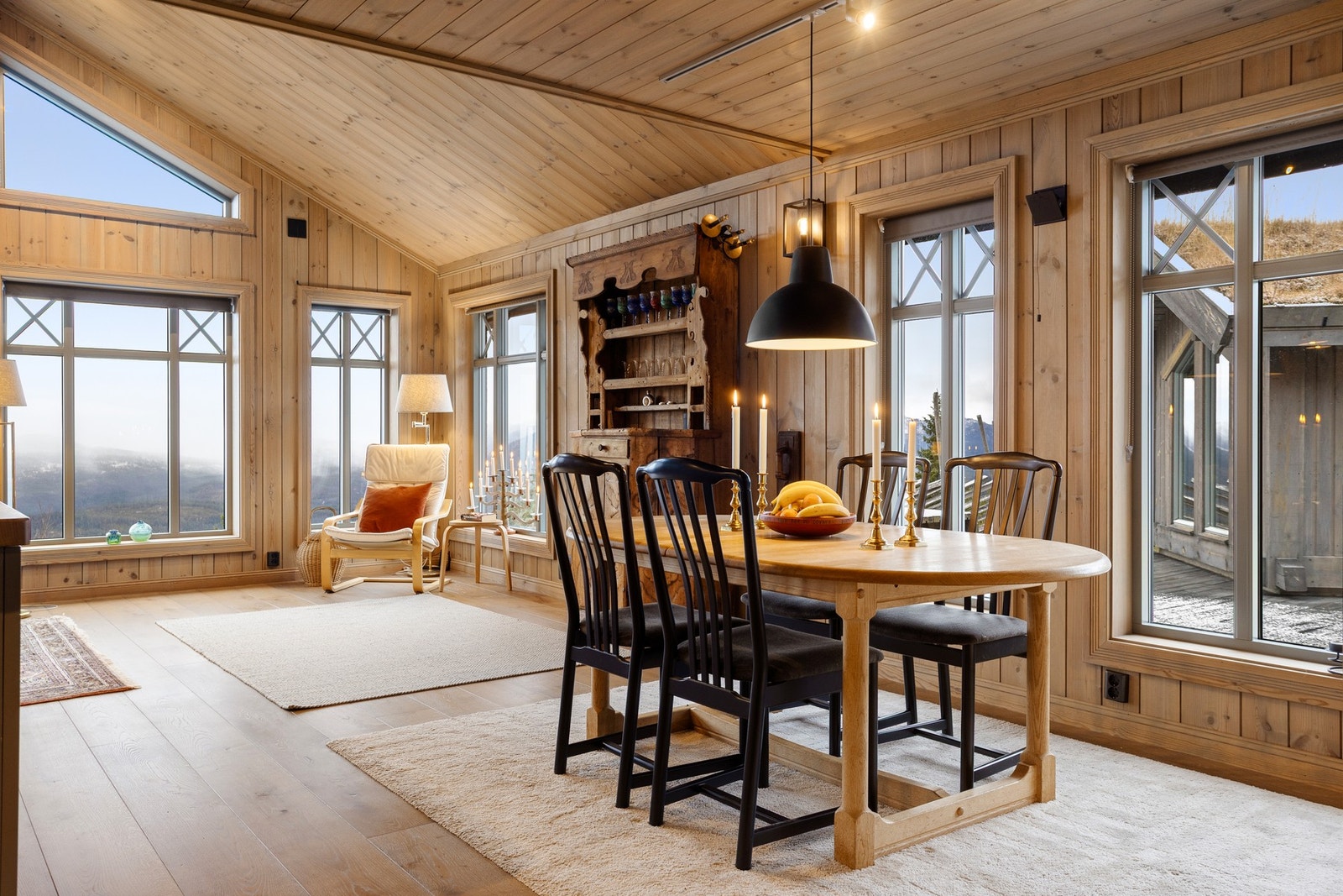 De mange vinduene bringer naturen inn i hytta. Galleribilde