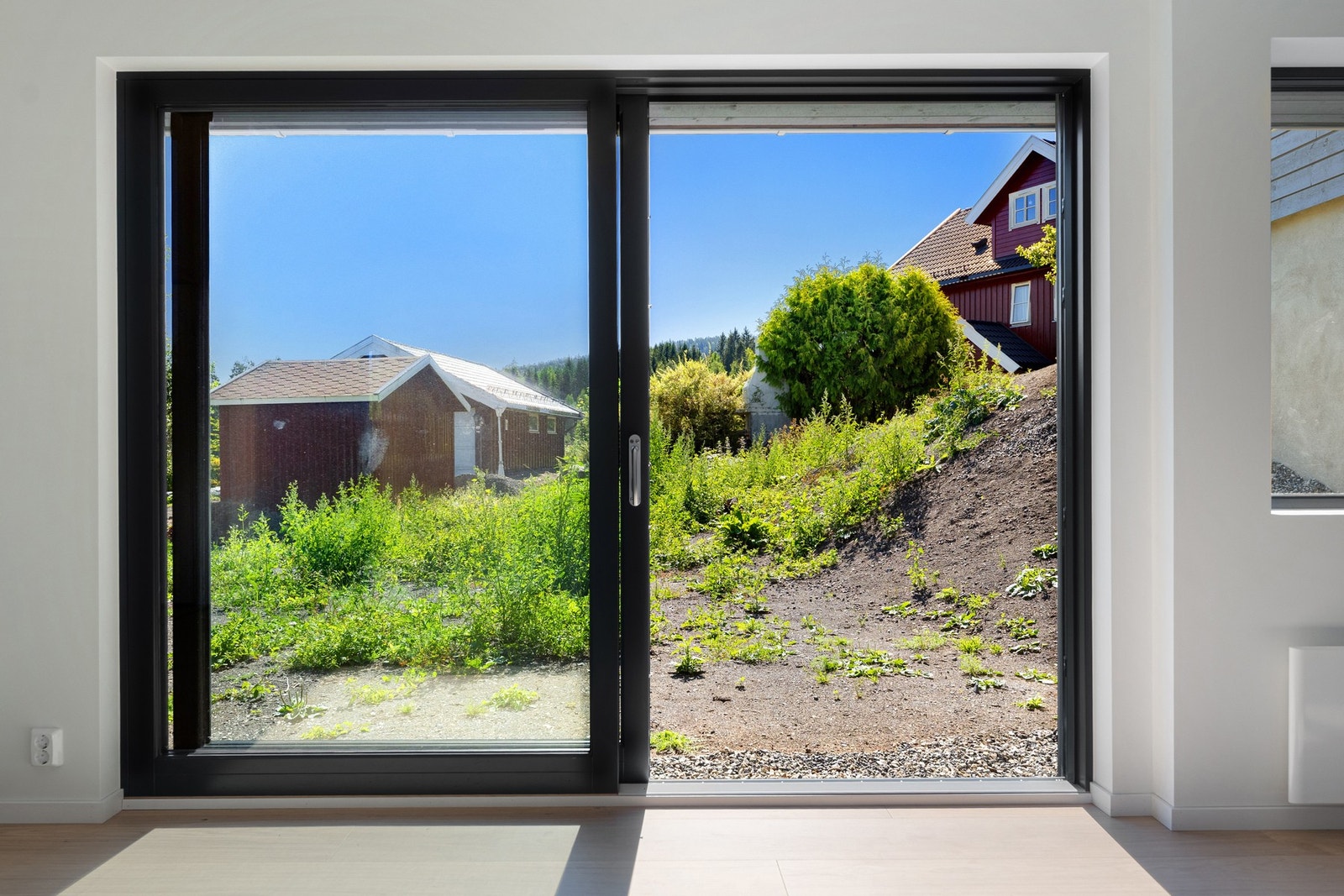 Fra stuen er det en stor skyvedør ut til hagen. Galleribilde