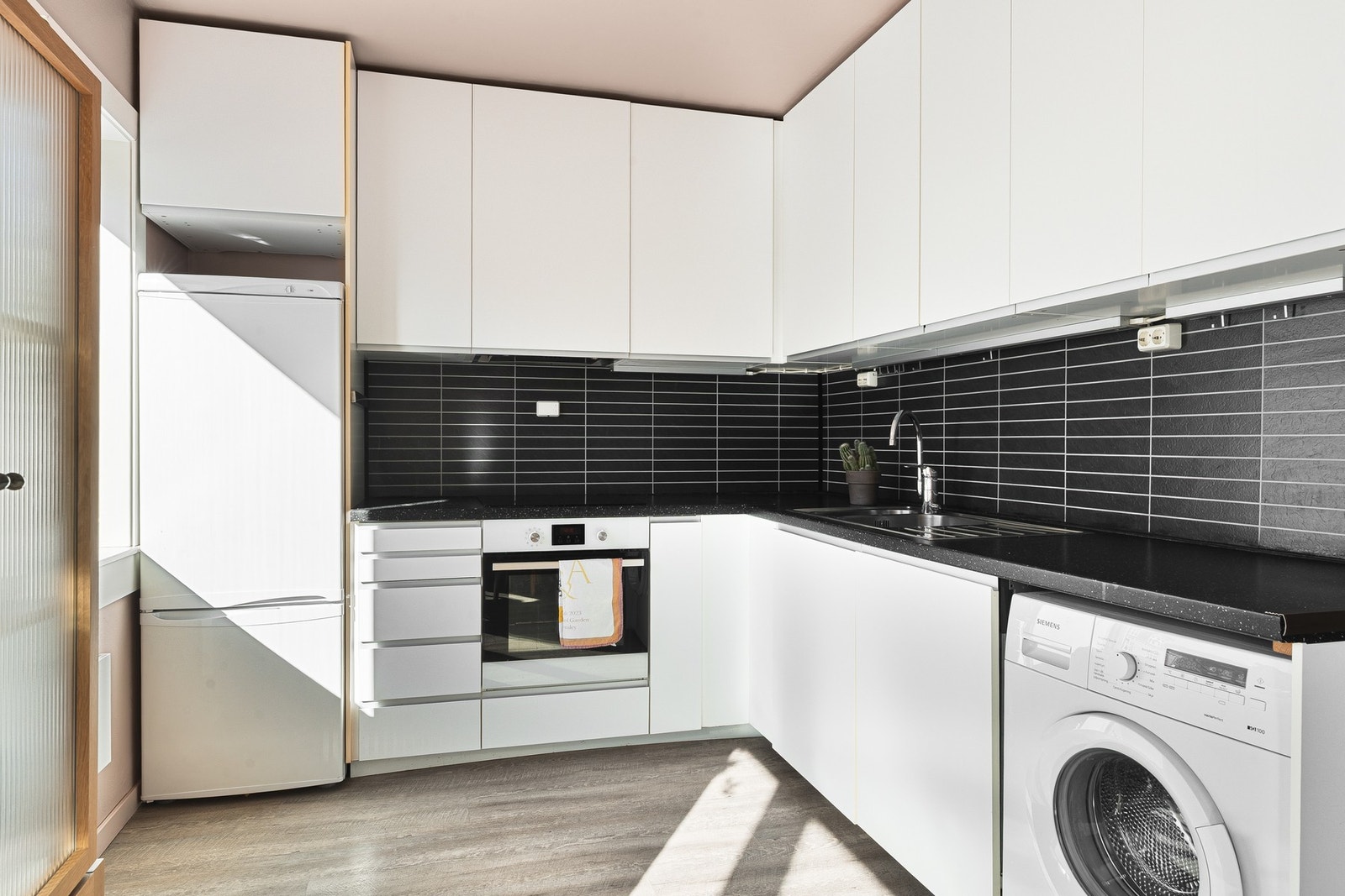 Kjøkkenet fra IKEA har godt med skap- og benkeplass og opplegg for vaskemaskin. Integrerte hvitevarer inkluderer stekeovn, platetopp og oppvaskmaskin. Galleribilde