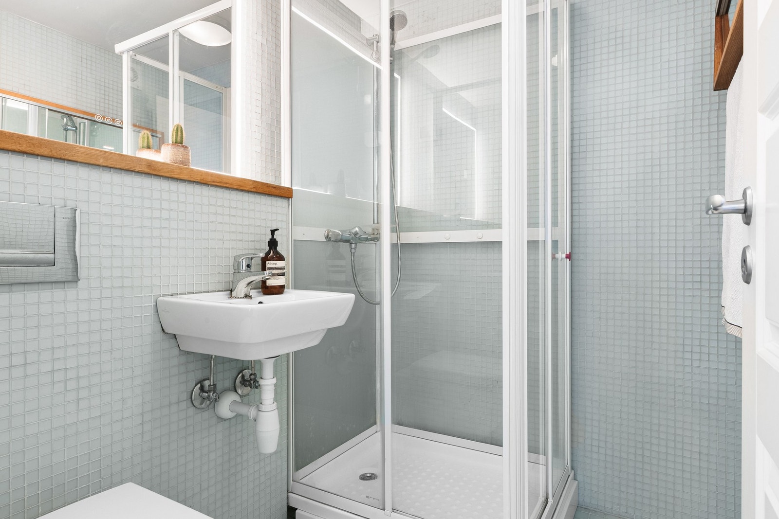 Badet er innredet med dusjkabinett, vegghengt toalett og servant. Galleribilde