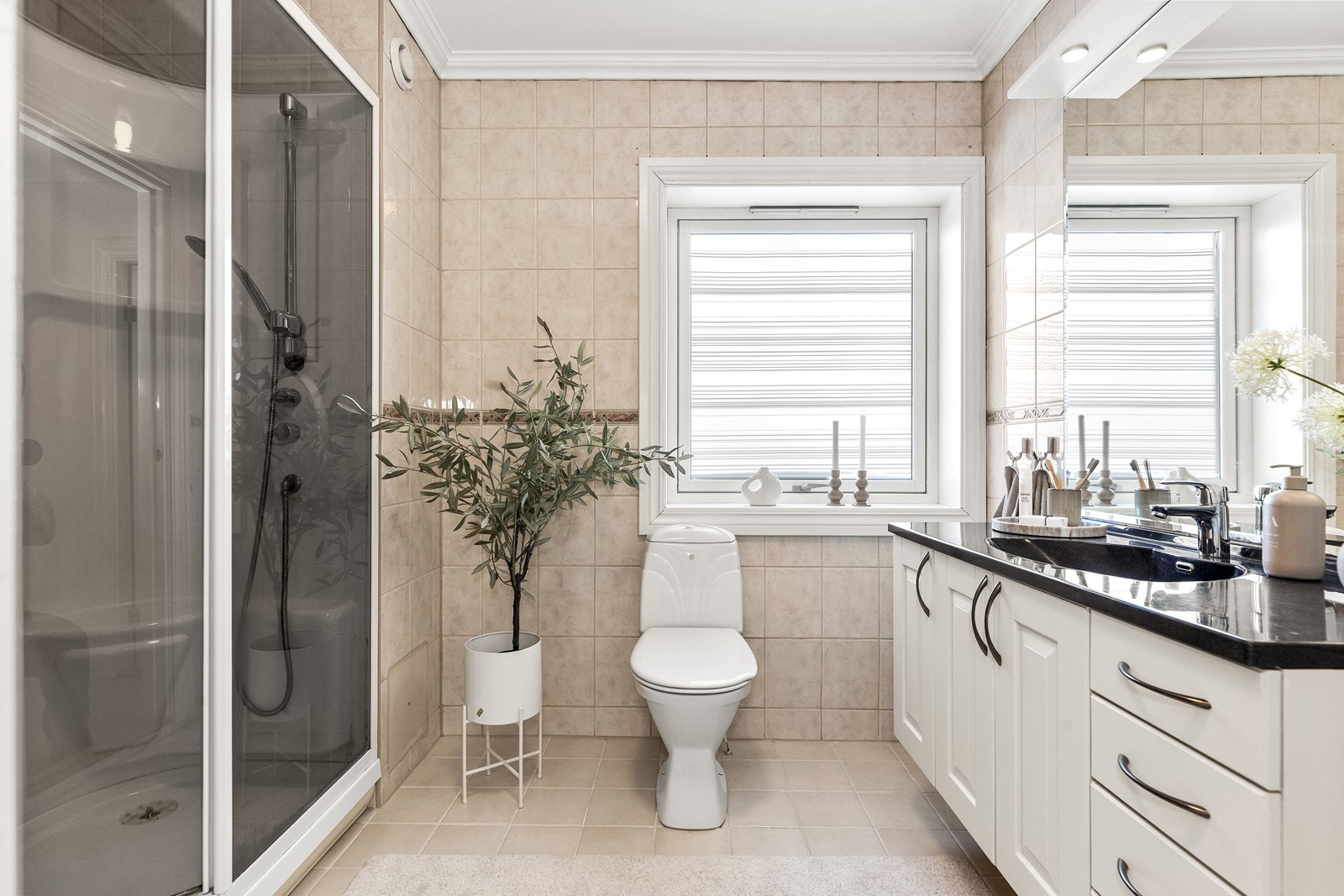 Badet er flislagt og har gulvmontert wc og dusjkabinett. Galleribilde